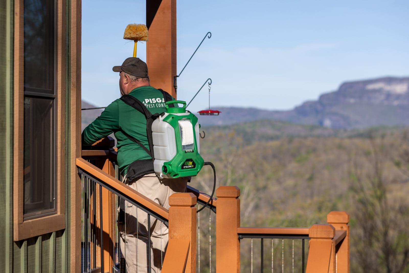 Pisgah Pest Control technician treating a mountain-view deck in Cashiers, NC